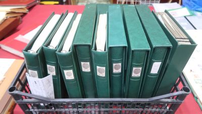 de nombreux livres verts dans un panier posé sur une table
