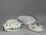 three pieces of porcelain with flowers and leaves on them