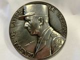 an image of a silver medal with a man ' s face on it