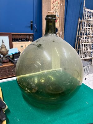 un grand vase vert posé sur un tapis vert