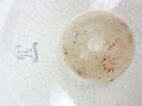 a close up of a white bowl with a red design on it