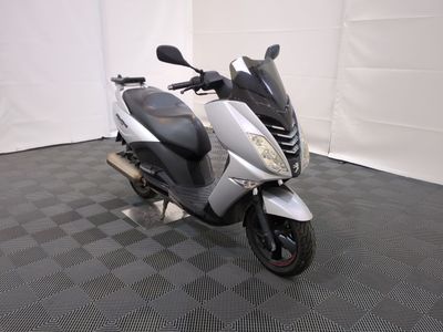 un scooter garé sur un sol à damier