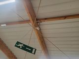 a green sign hanging from the ceiling of a building