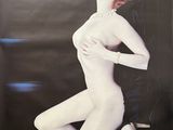 une image représentant une affiche sur laquelle figure une femme vêtue d'un body blanc