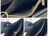 the inside of a purse with a zipper open and a hand holding it