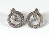 a pair of silver earrings with twisted wire on a white background