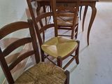 four wooden chairs lined up against a wall in a room