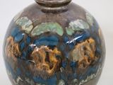 a brown vase with blue and yellow designs on it