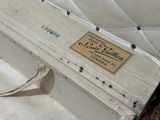 a white suitcase with a label on it sitting on the ground