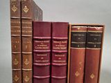 Quatre livres sont alignés sur une surface grise