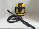 un aspirateur jaune et un tuyau noir posés sur une étagère blanche