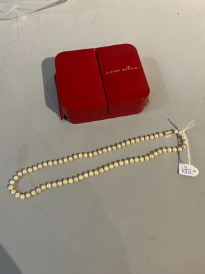 une boîte rouge contenant un collier de perles blanches et une boîte rouge contenant un collier de perles blanches
