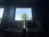 two microwaves sitting on a table in front of a window