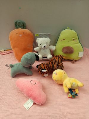 beaucoup de peluches posées sur le lit