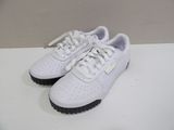 white puma sneakers with black soles on a white surface