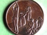 an image of a bronze medal with a man and a woman on it