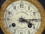 a black and gold clock with a white face