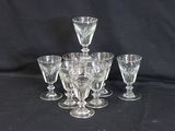 quatre gobelets en verre transparent et quatre verres à vin sur fond noir