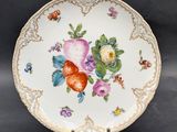 a plate with flowers and fruit on it on a table