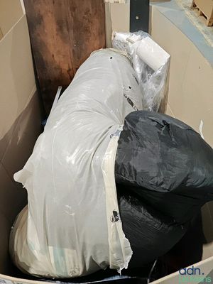 une poubelle pleine de déchets posée au milieu d'une pièce