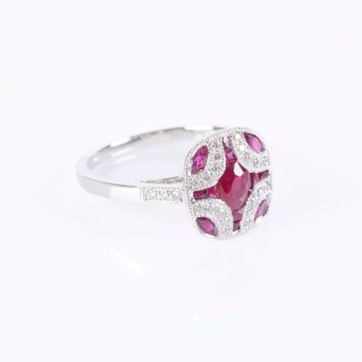 a close up view of a ruby and diamond ring on a white background