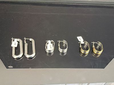 four pairs of earrings on display in a display case