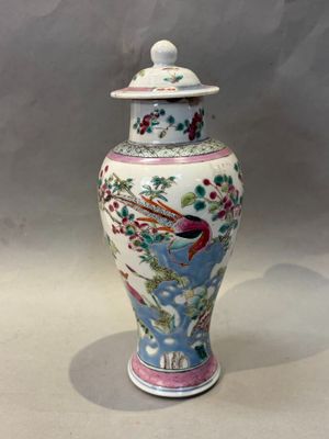 un vase avec un oiseau posé sur une table