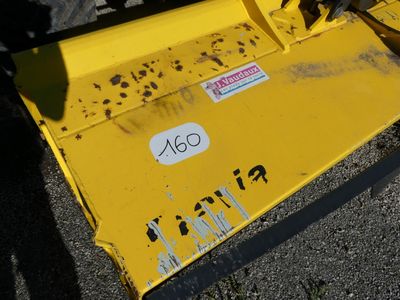 the front end of a yellow snow plow sitting on top of a parking lot