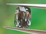 quelqu'un tient une pince sur laquelle est monté un diamant
