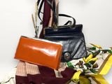 a black purse and a yellow scarf on a white surface