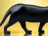 une figurine représentant un chat noir posée sur une table