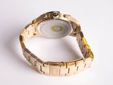 a close up of a gold watch on a white surface