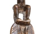a statue of a man sitting on top of a stool