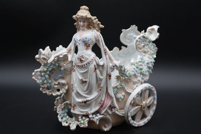 Sujet en porcelaine représentant une femme sur le char. 