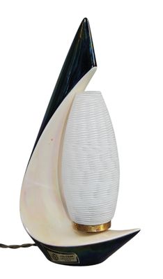 a white and black lamp that is on top of a table