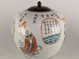 un vase blanc orné d'inscriptions asiatiques, posé sur une table