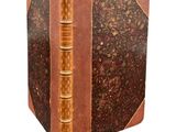 an old book sitting on top of a white surface