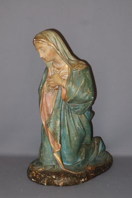 the statue of the virgin mary is sitting on the ground