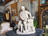 a statue of a man sitting on a chair