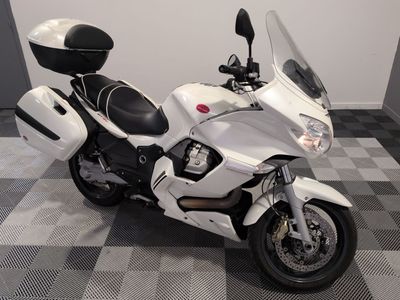une moto blanche garée sur un sol à damier