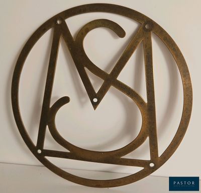 un gros plan d'une horloge en métal sur laquelle figure la lettre « a » dans un cercle