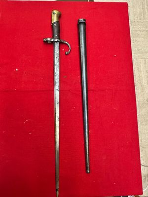 an old sword is laying on top of a red cloth