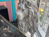 une statue représentant un lion assis à côté d'une table