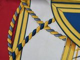 a close up of a scarf with a cross on it