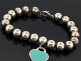 un bracelet orné d'une breloque en forme de cœur sur un fond noir