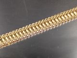 gros plan d'un bracelet en or sur une table