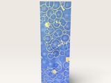 une boîte bleue ornée de bulles, posée sur une surface blanche