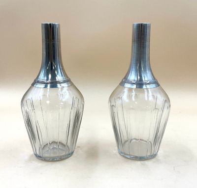 une paire de salières et poivrières en verre transparent posées sur une surface blanche