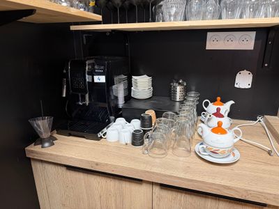 une théière et des tasses posées sur un plan de travail dans une cuisine