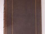 un vieux livre en cuir marron, orné d'une bordure dorée sur fond blanc